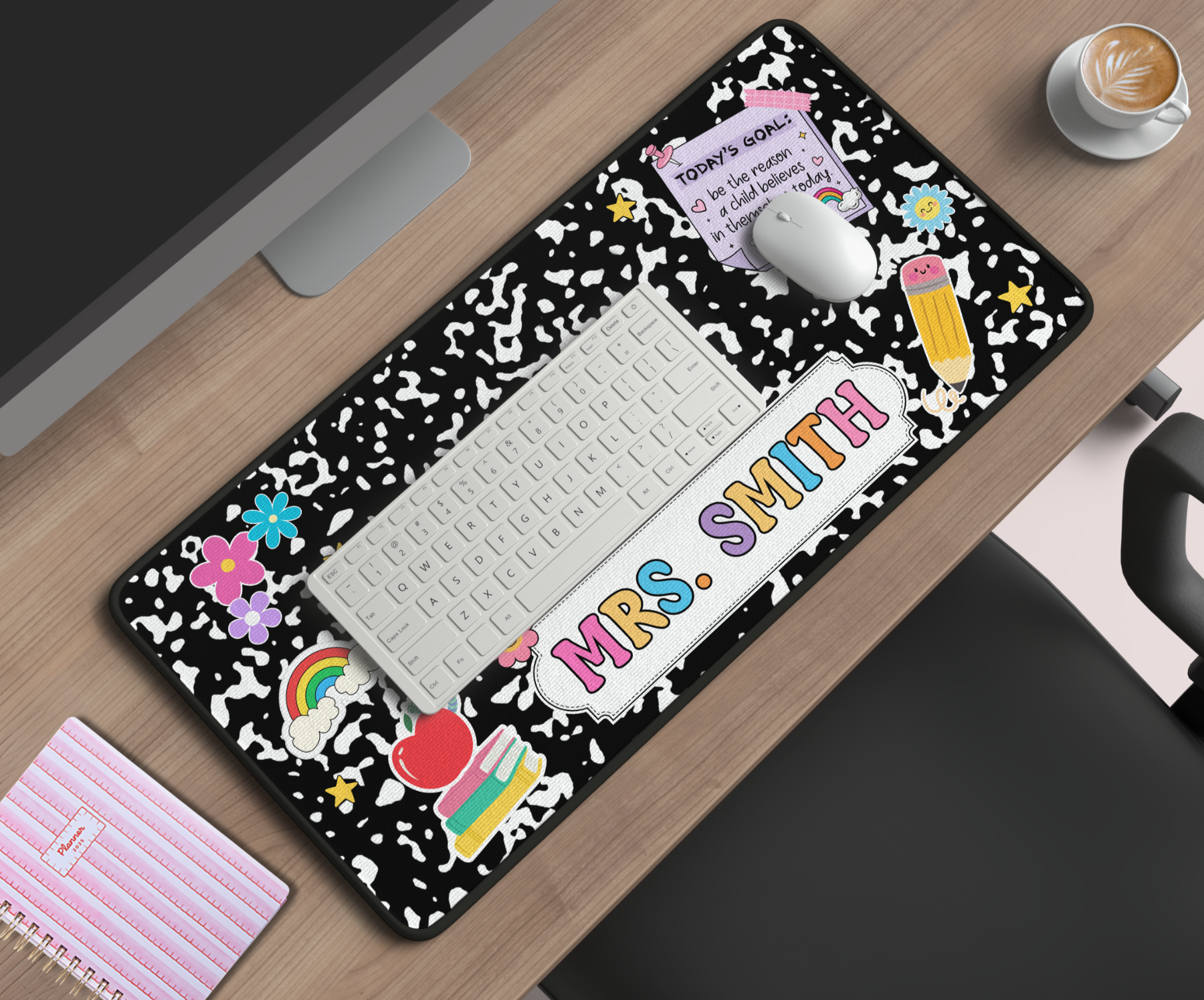Personalized desk mat with 'MRS. SMITH' on a wooden desk with office items.